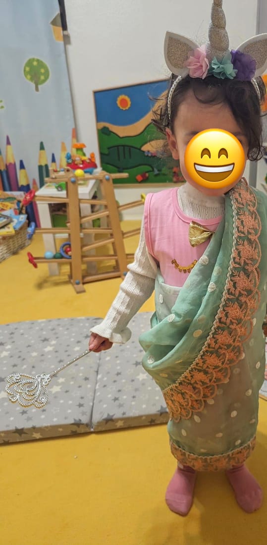 Ein als Einhorn-Fee verkleidetes Kind mit Zauberstab im Spielzimmer